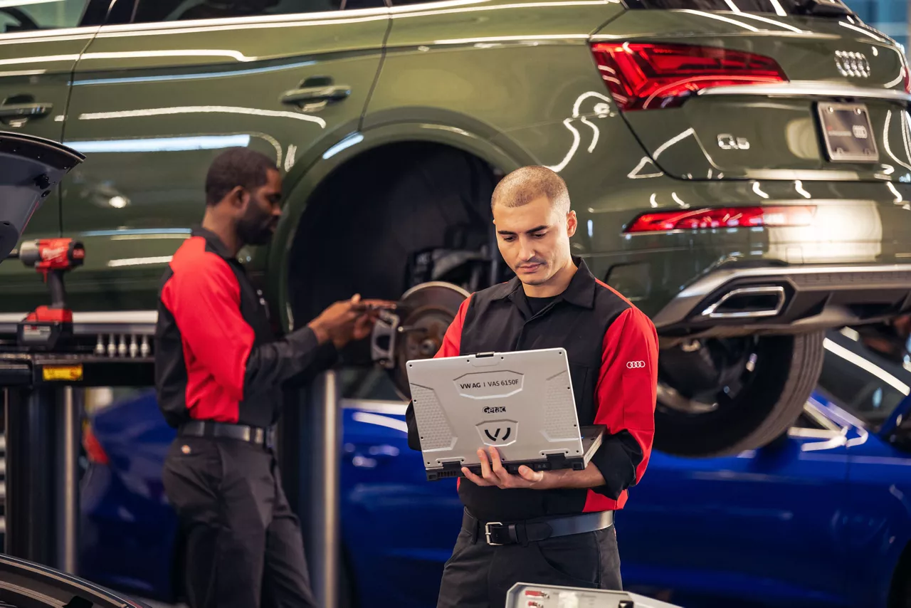 Audi service technician servicing a vehicle.