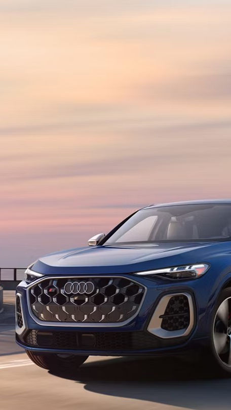 Left side profile view of an Audi Q6 accelerating.