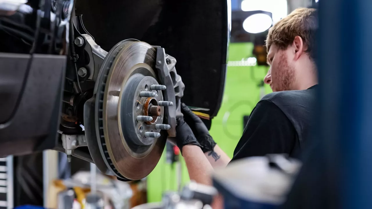 Audi service technician servicing a vehicle.