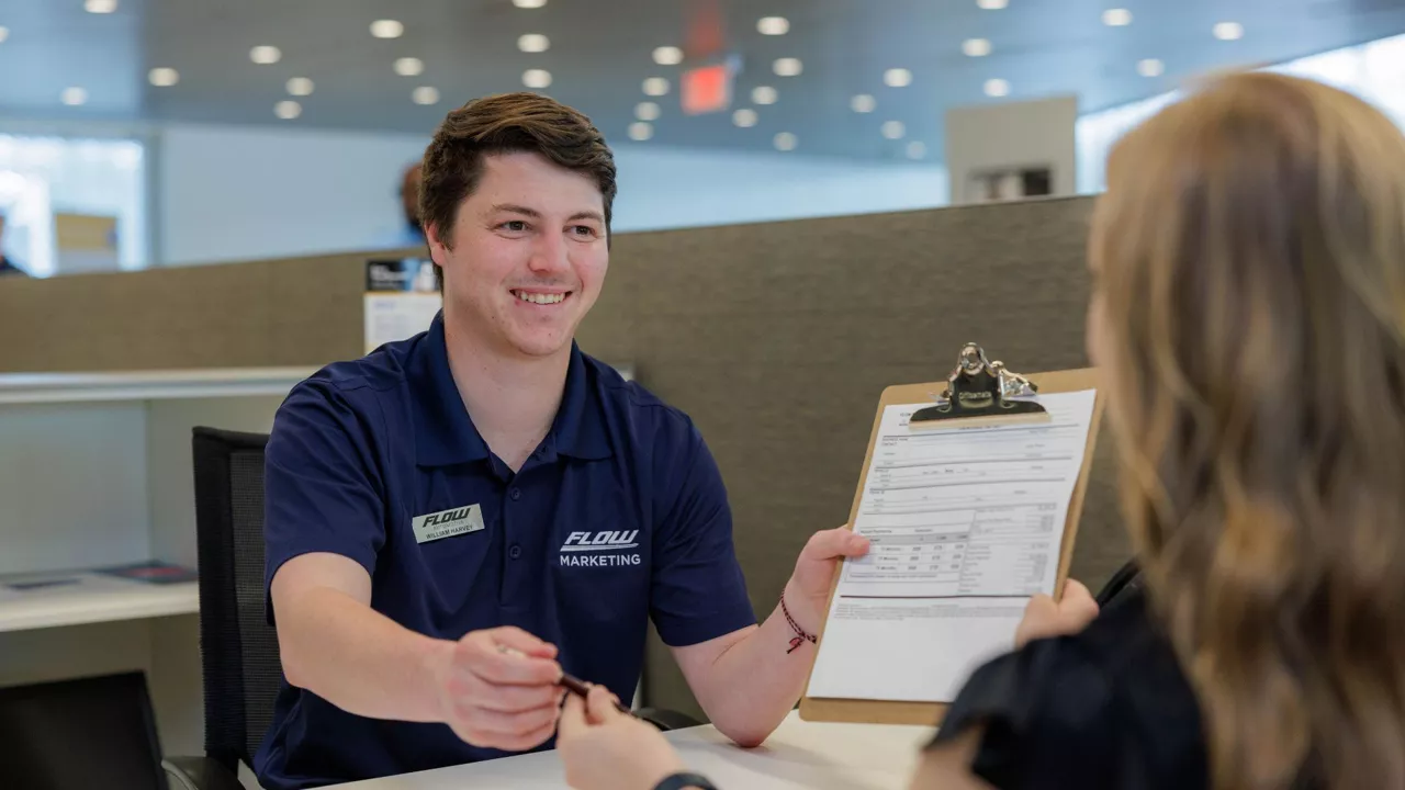 An Audi dealer explaining the features of an Audi vehicle steering wheel to a customer.