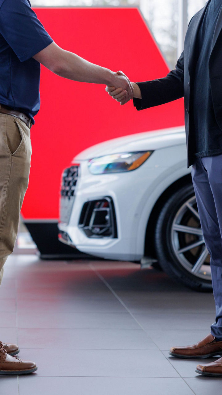 Audi employee and a customer shaking hands.