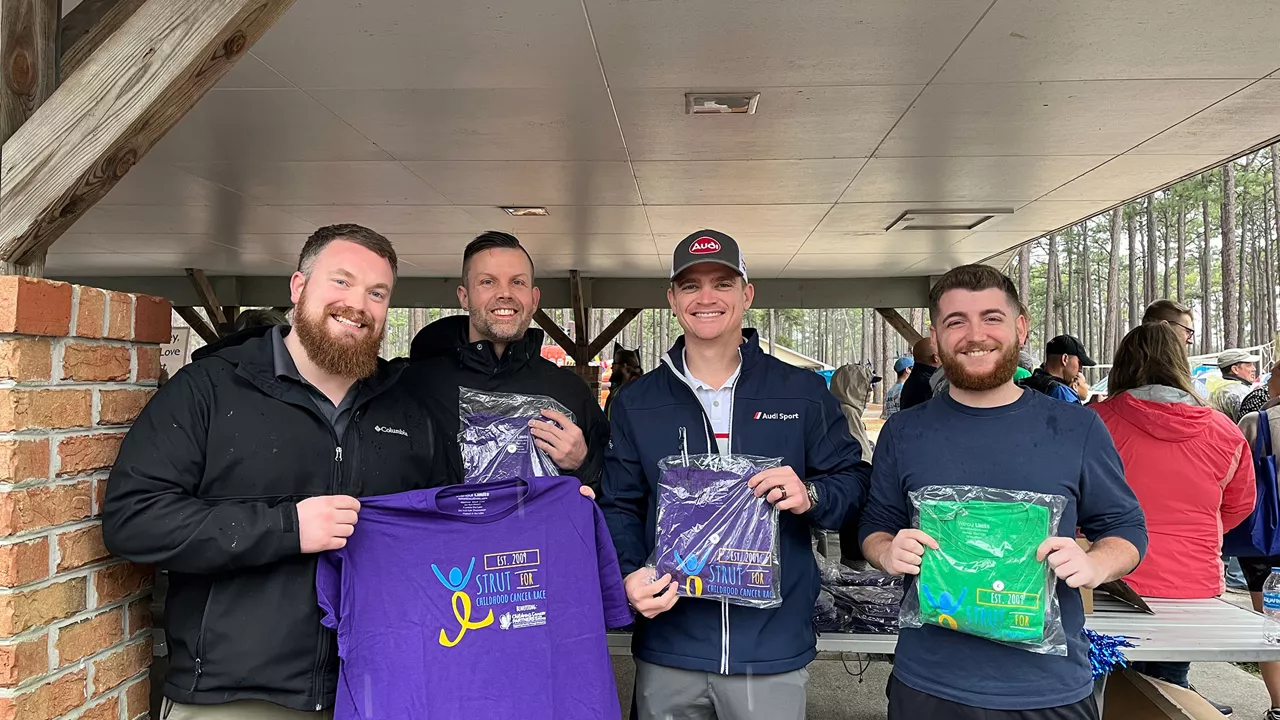 A group of men holding t-shirt from a community run