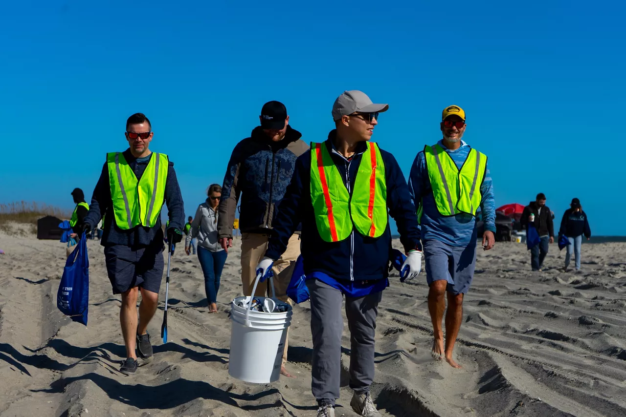 Guys on a beach cleaning up.