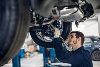 Service technician servicing vehicle.