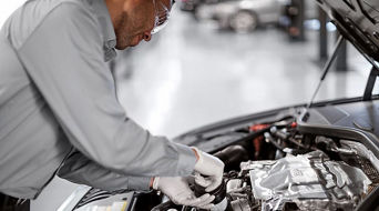 Service technician servicing vehicle.