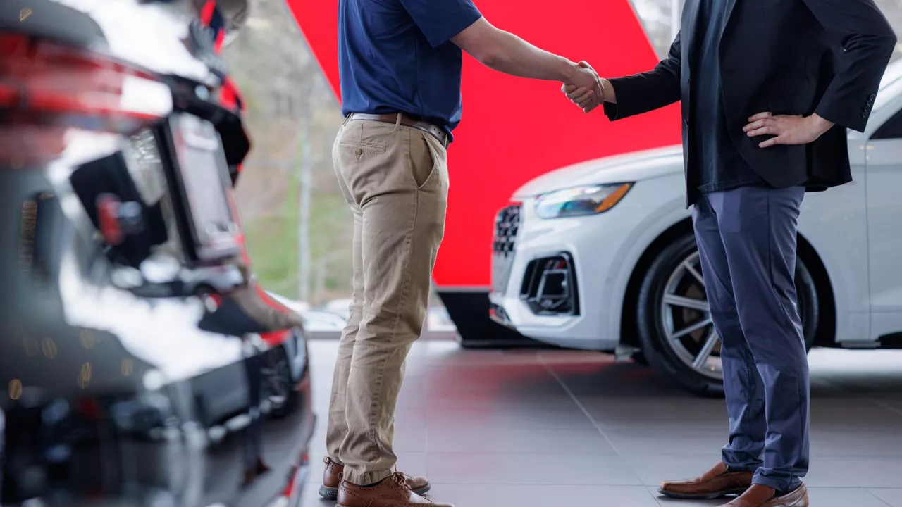 Audi employee shaking hands with a customer.