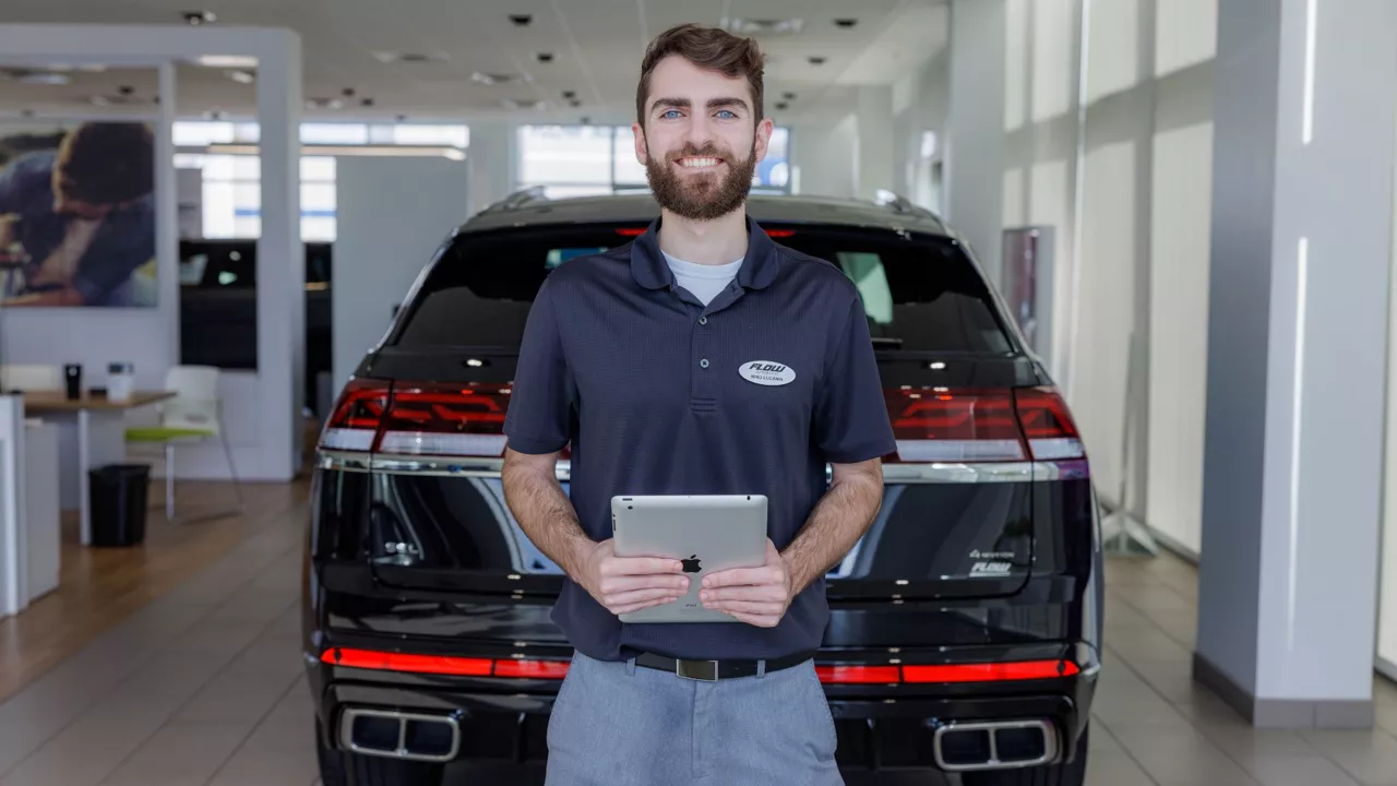 Audi employee standing in front of the Audi vehicle.