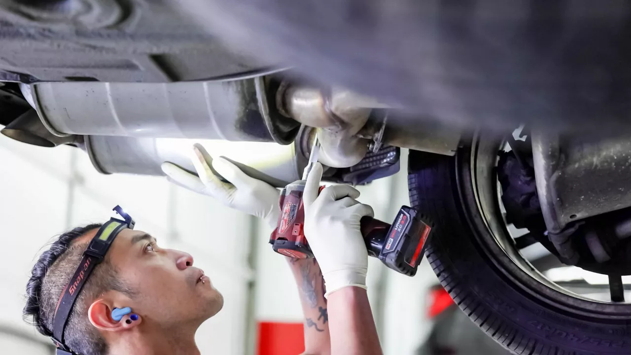 Audi service technician servicing a vehicle.