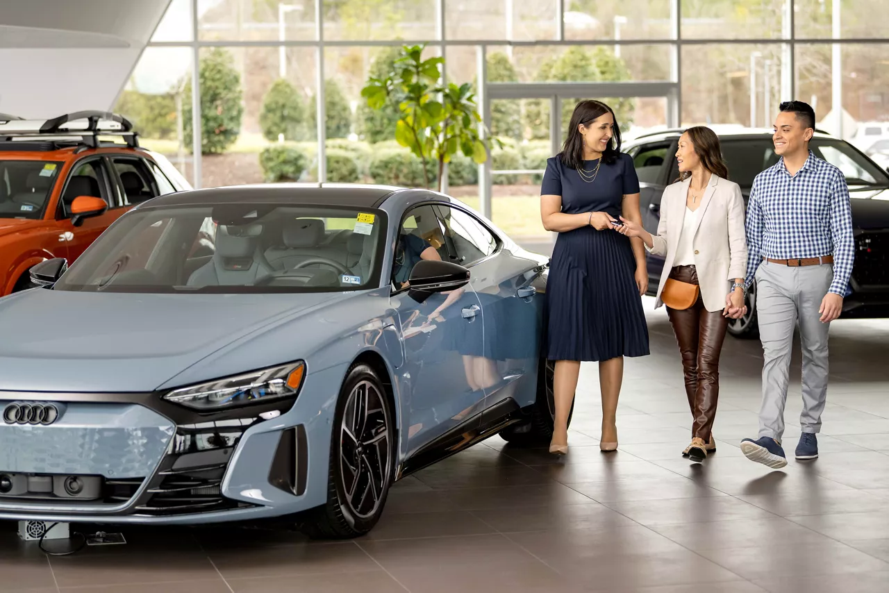 Image of Audi Brand Specialist walking with a couple of customers.