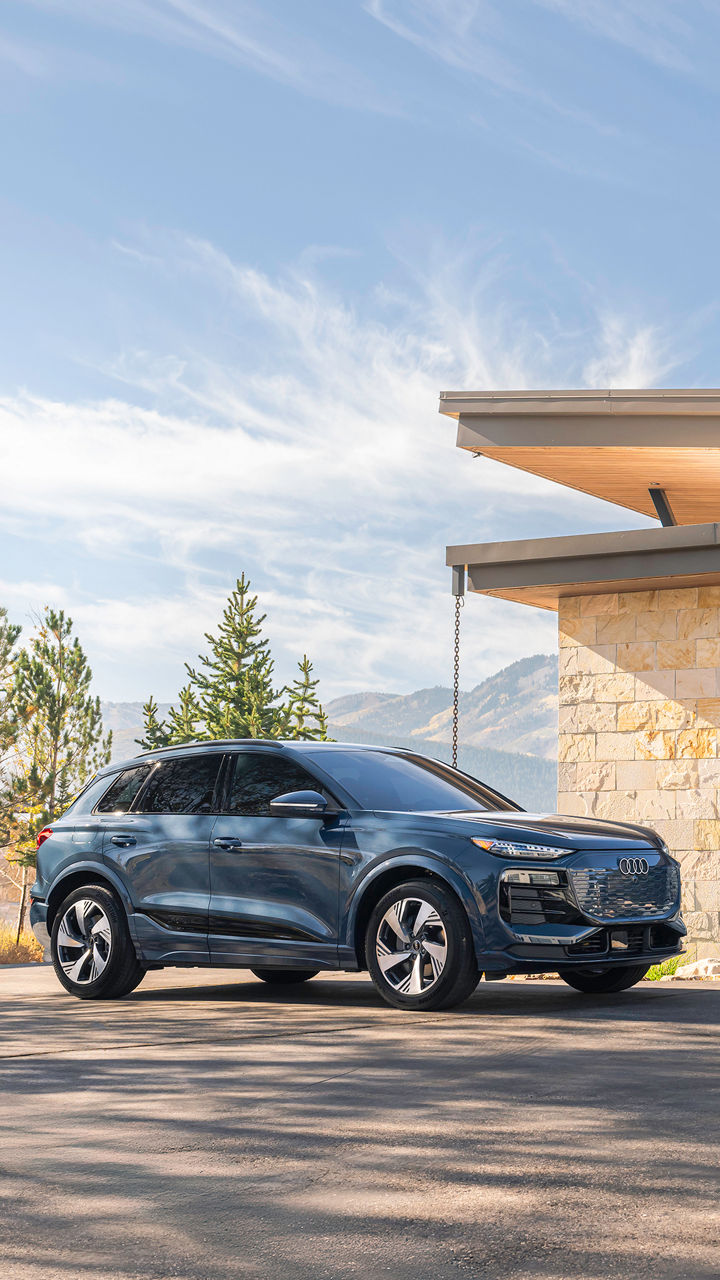 Left side profile view of an Audi Q6 parked.