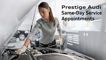 Audi technician under the hood of a vehicle