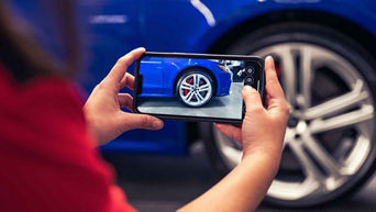 Service technician taking a picture of the tire of a vehicle.