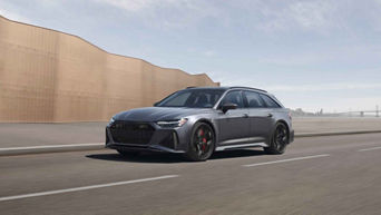 Three-quarter front view of a dark silver Audi RS 6 in motion.