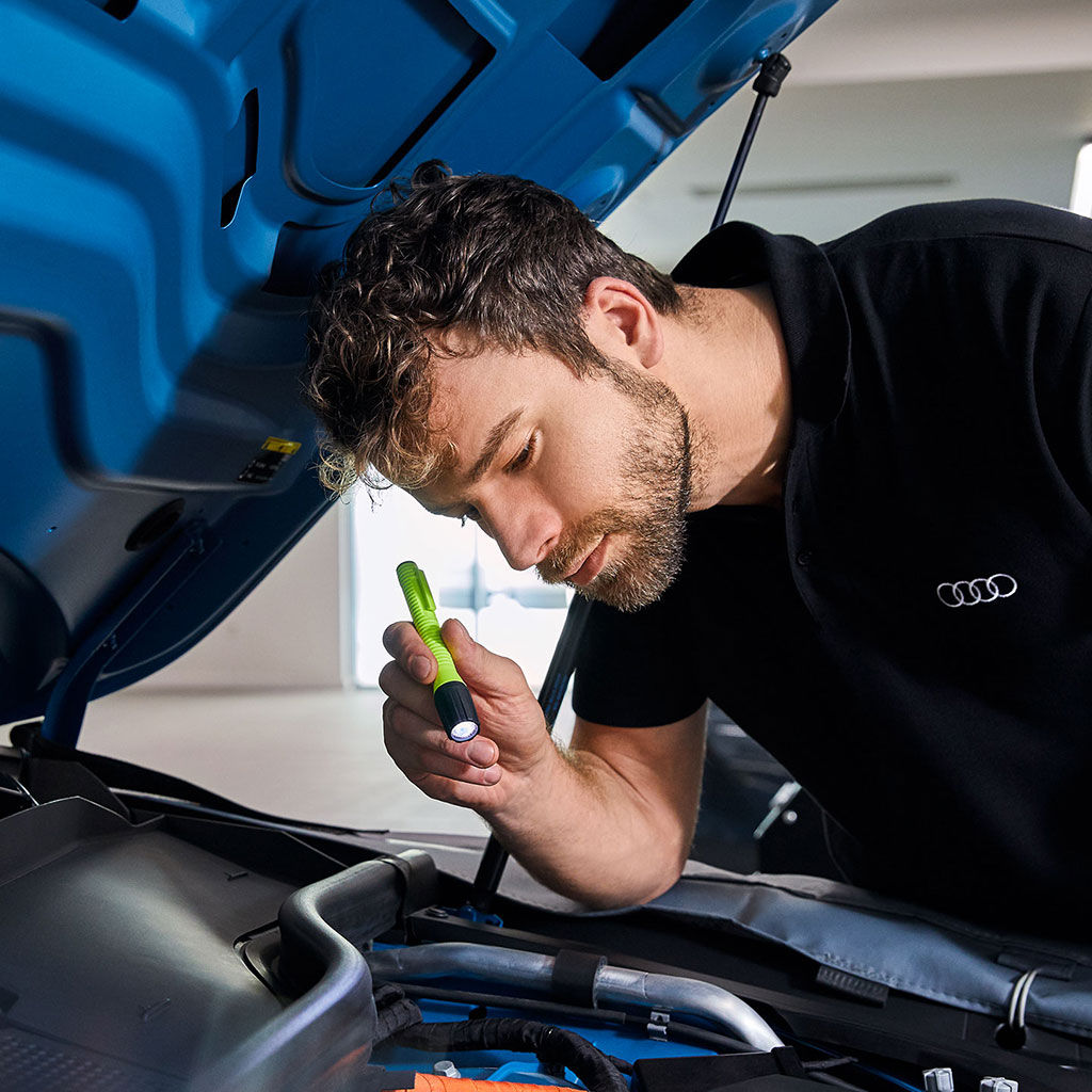 An Audi technician servicing a vehicle. 