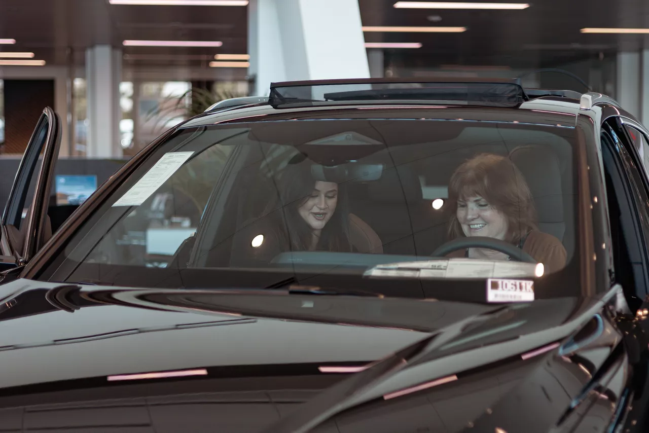 Audi sales specialist sitting in a vehicle with the customer discussing the features in the showroom.