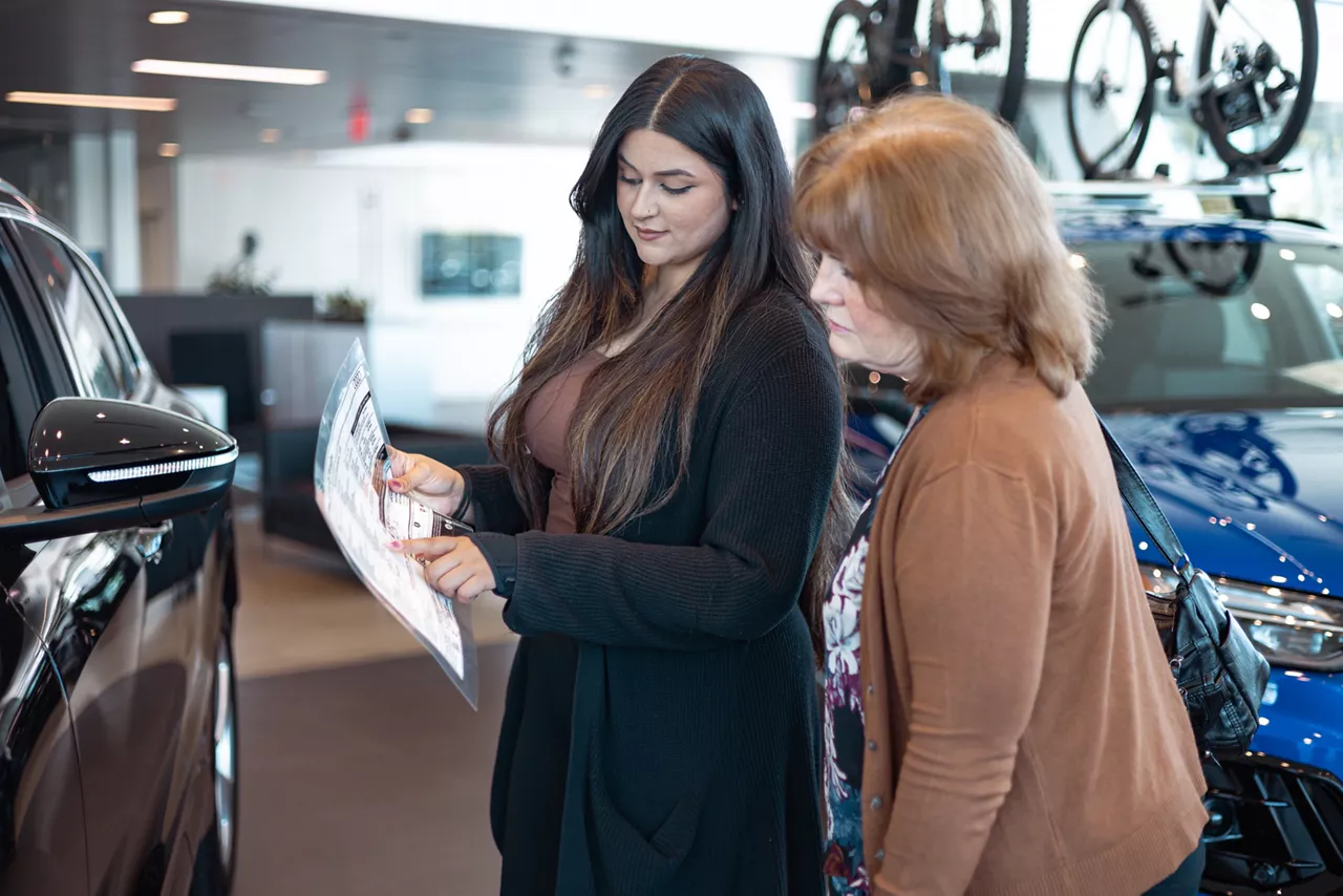 Audi employee explaining a deal to a customer.