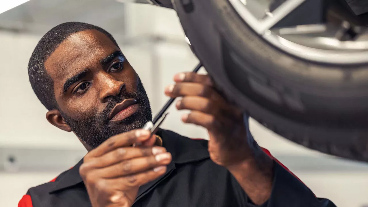 Audi service technician servicing a vehicle.