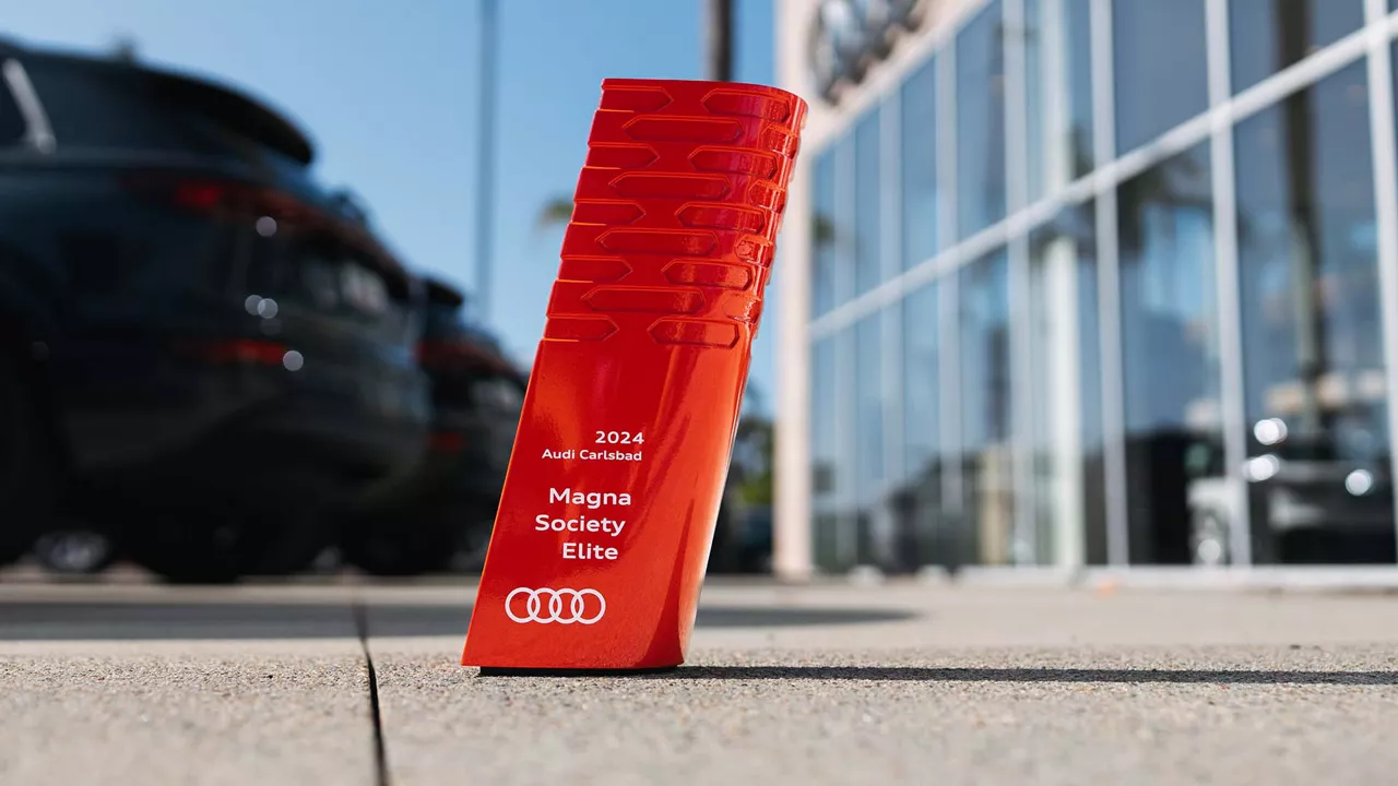 Audi Carlsbad Magna Society Elite Award in front of the Audi Carlsbad dealership