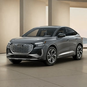 Front 3/4 view of a grey Audi Q4 Sportback e-tron parked in a modern building