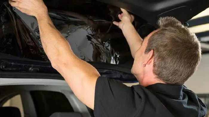 Audi mechanic inspecting vehicle damage in the collision repair shop