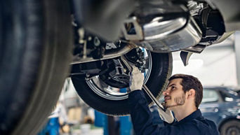 Technician checking the engine area of an Audi after a collision