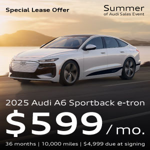 A white A6 Sportback e-tron driving along the water with a sunset