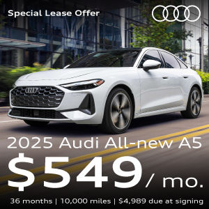 A white Audi A5 driving on the street.