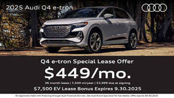 Three quarter view of an Audi q4 e-tron parked with trees in the the background.