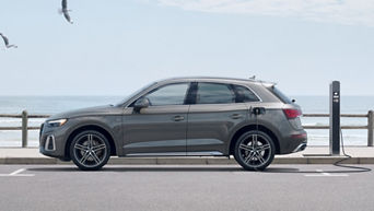 A Q5 hybrid being charged by the beach.