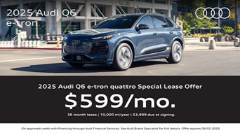A blue Audi Q6 e-tron driving through the city on a sunny day.