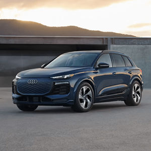 Front 3/4 view of a blue Audi Q6 e-tron parked outside a modern building