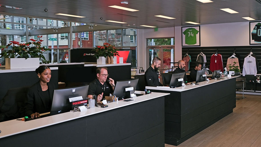 Receptionists working at desk in dealership