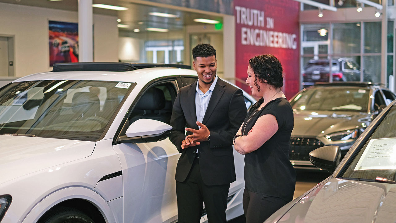 Audi sales advisor talking to customer in showroom