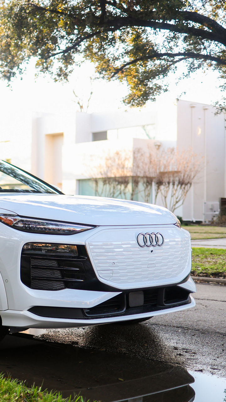Left side profile view of an Audi Q6 e-tron accelerating.