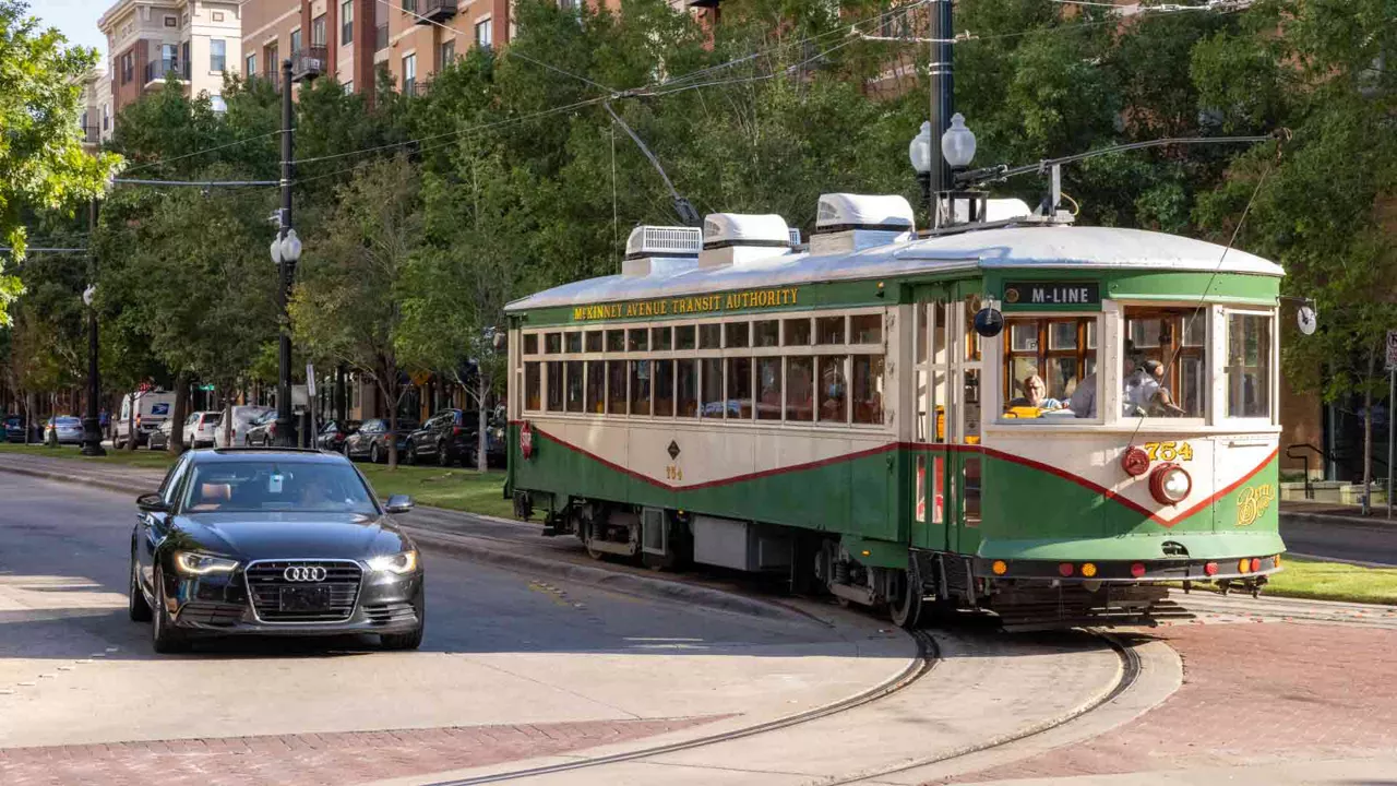 Front view of an Audi vehicle on a city street next to a tram. 