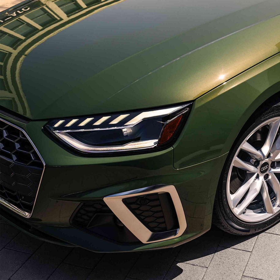 Close-up of the front wheel and headlight of an Audi vehicle.