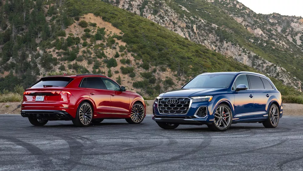 Exterior side profiles of Audi SUVs parked.