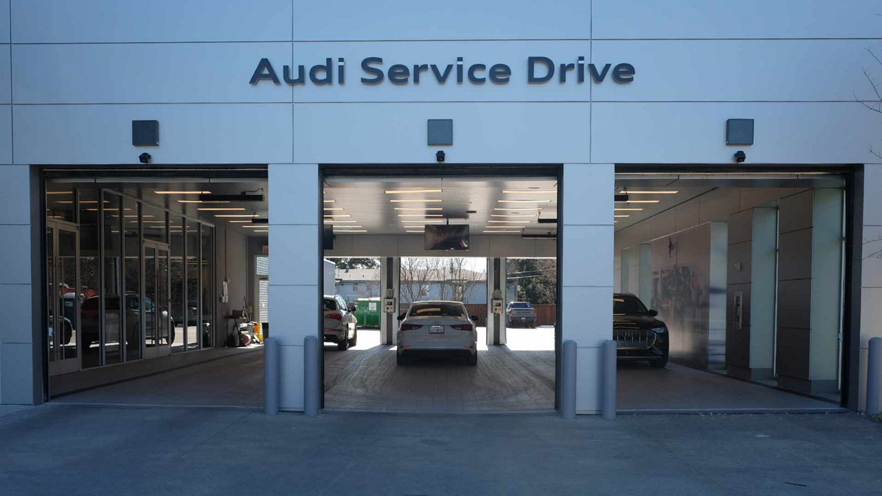 Rear view of several Audi vehicles in a garage. 