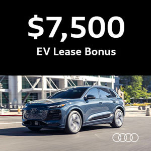 Audi driving by a building