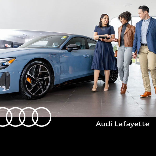 Audi Sale Specialist walking through the showroom with a couple.