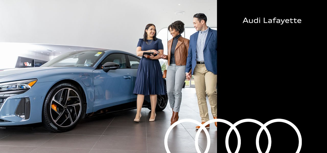 Audi Sale Specialist walking through the showroom with a couple.