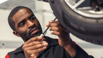 Service technician servicing vehicle.