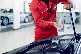 Technician doing oil check with bucket.