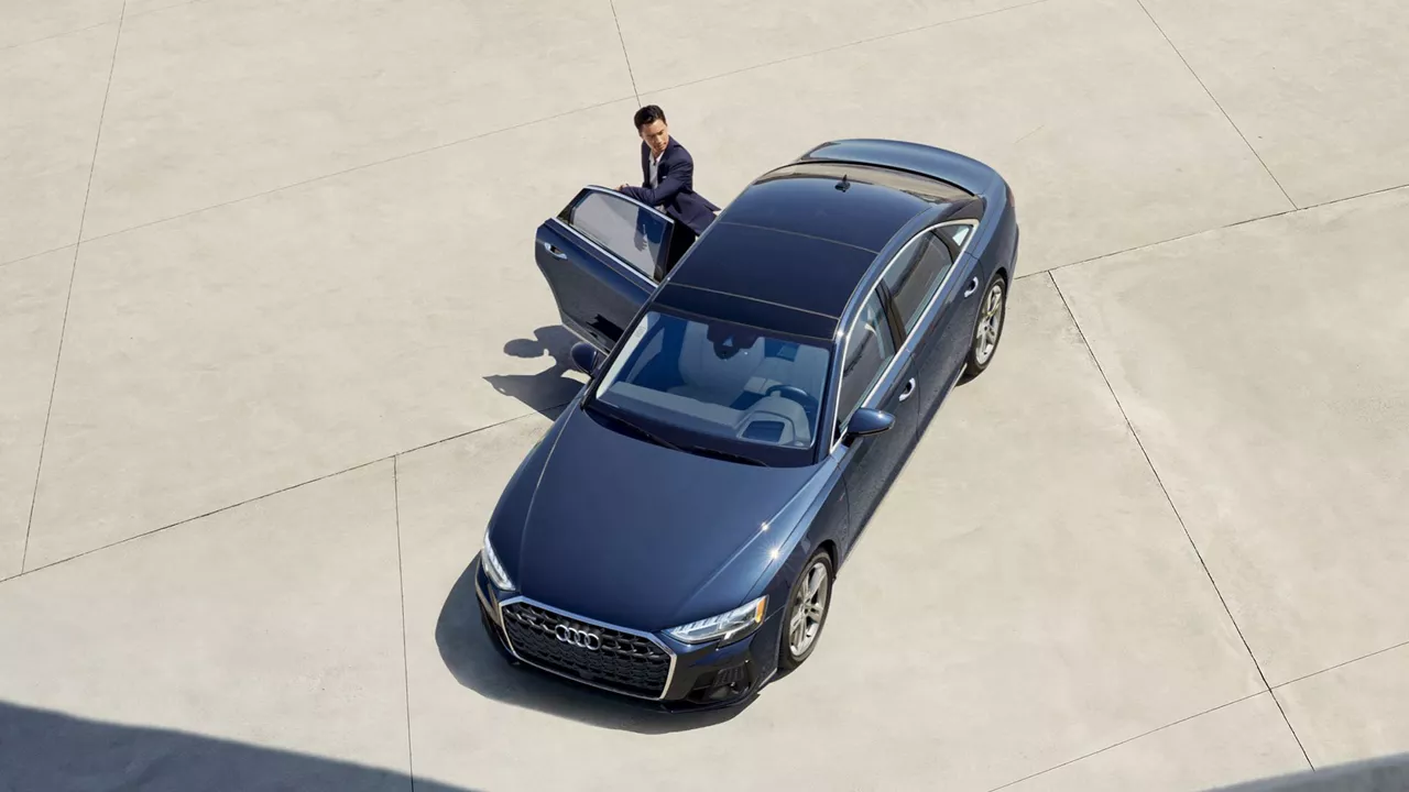 Birds eye view of man stepping out of Audi on top of parking garage