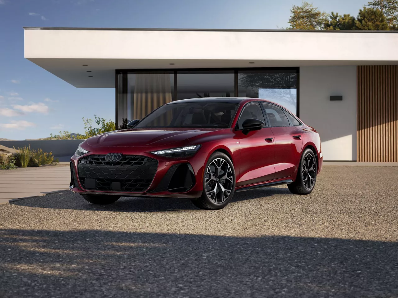 2026 Audi A6 Prestige trim in red parked infront of a modern house