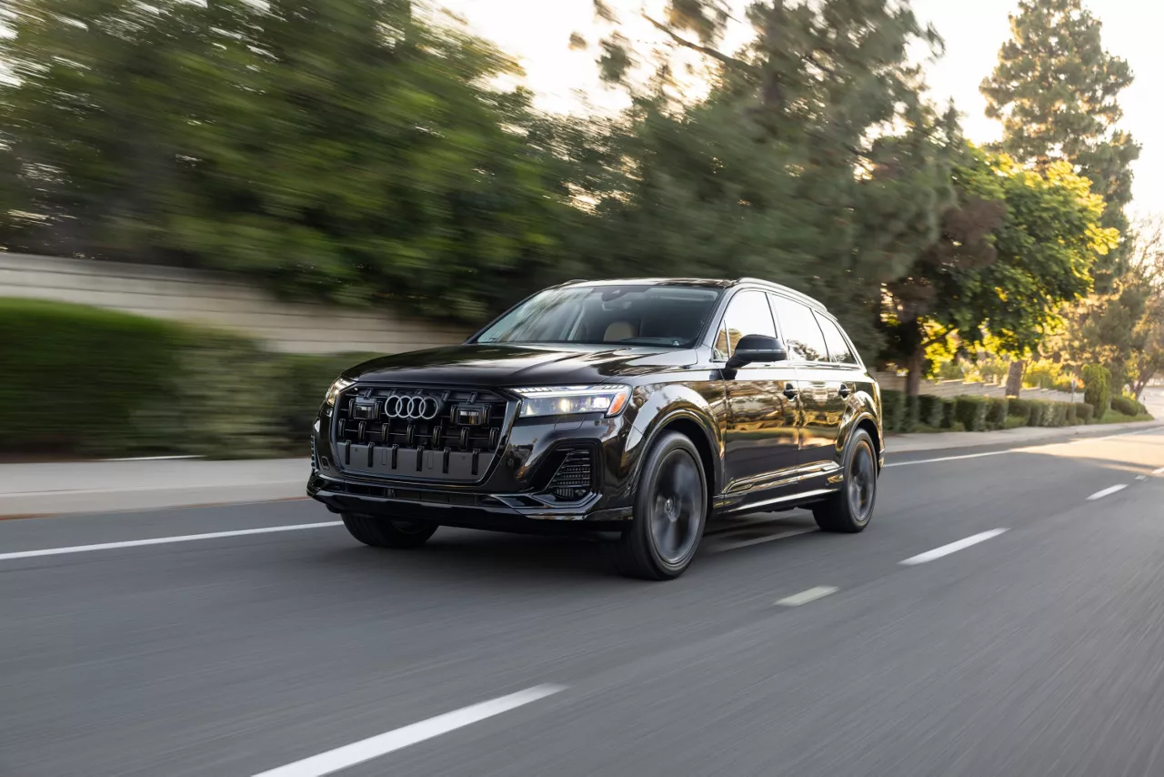 2026 Audi Q7 in black speeding down a wooded highway