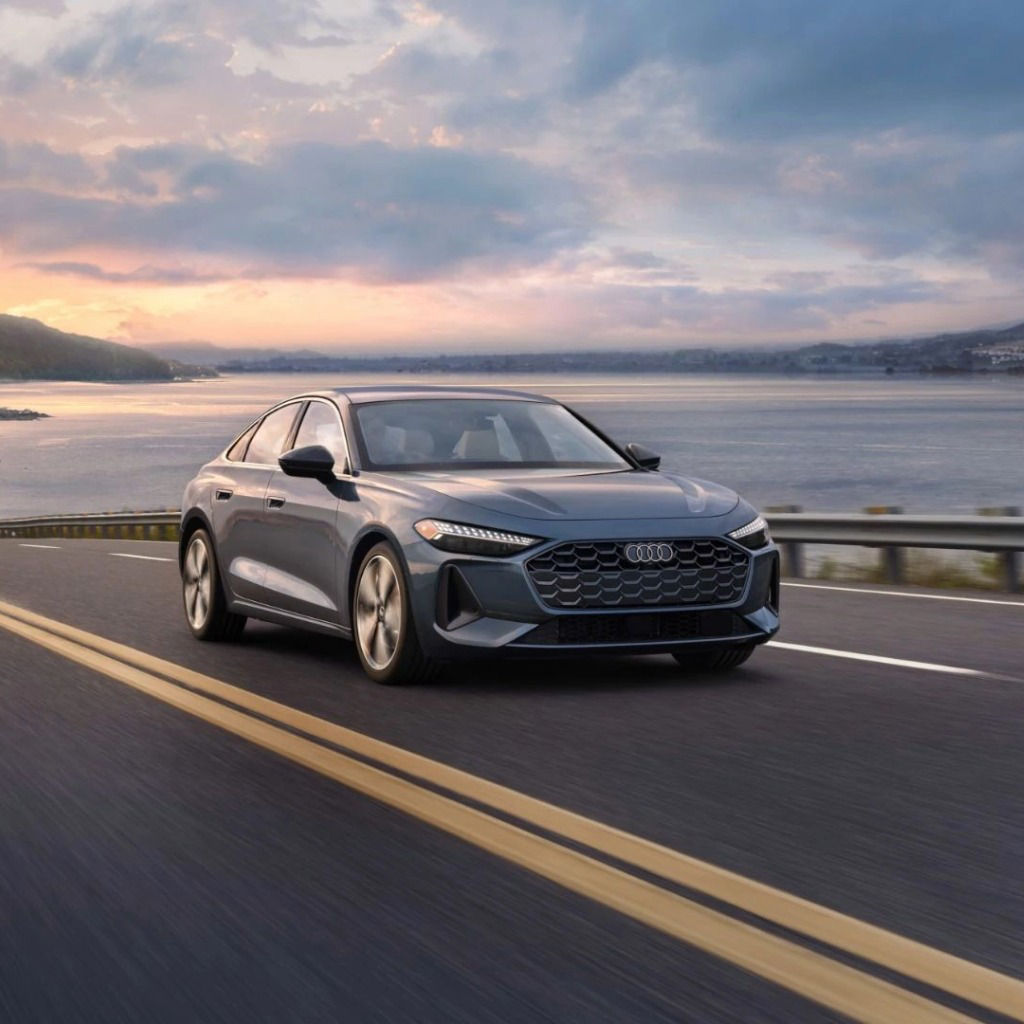 Audi driving on the highway by the coastline.