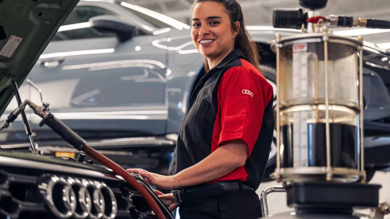 Audi service technician servicing a vehicle.