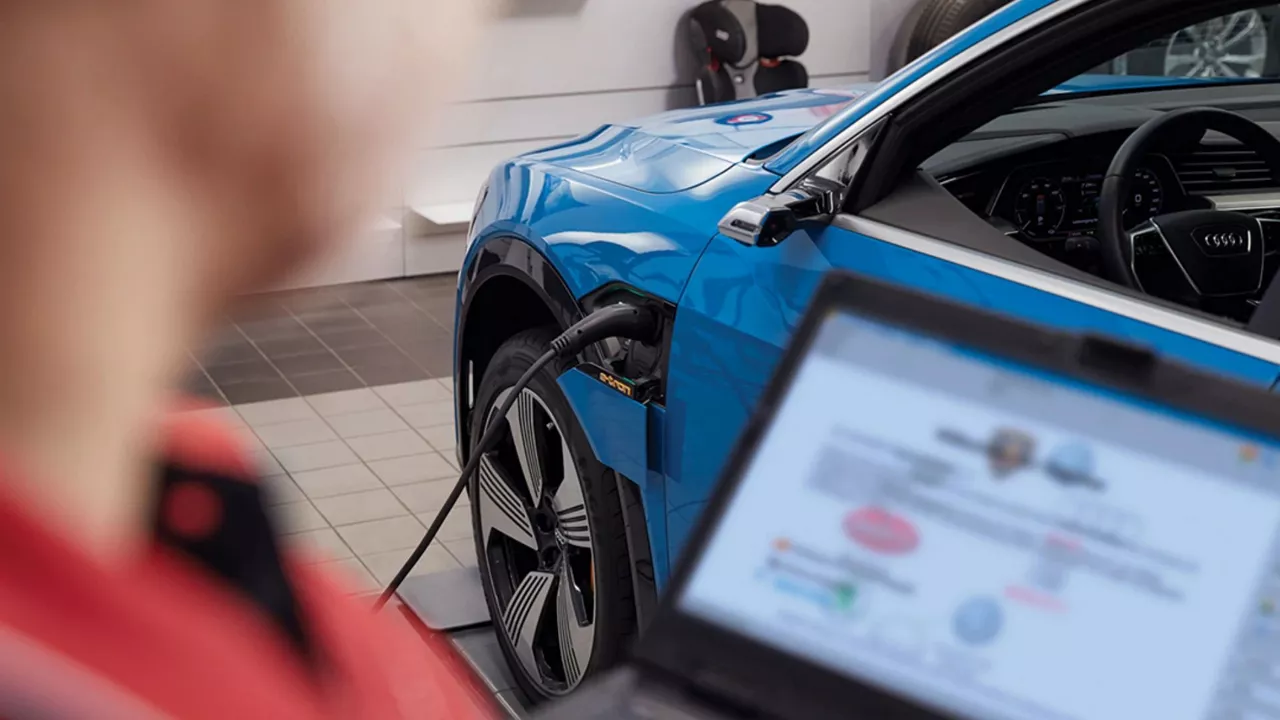 Audi service technician servicing a vehicle.