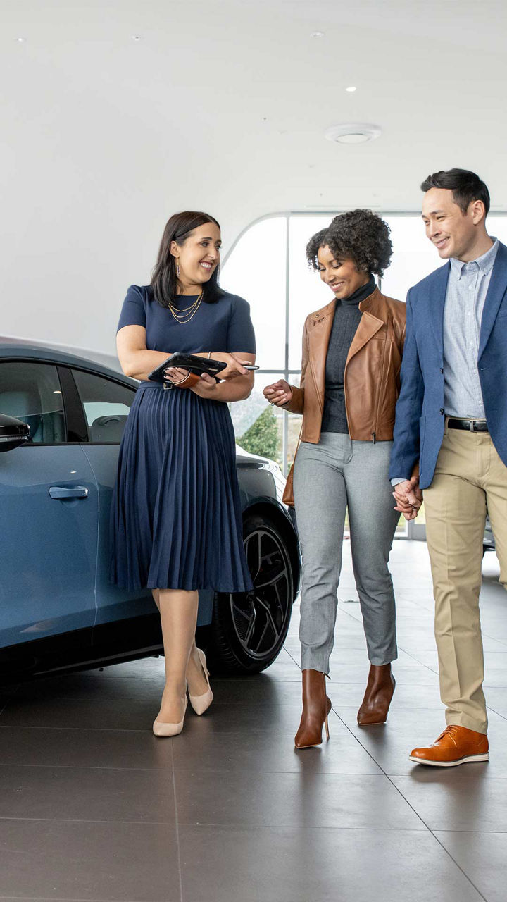 Audi Sale Specialist walking through the showroom with a couple.